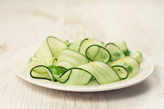 Sliced green cucumbers salad with cilantro