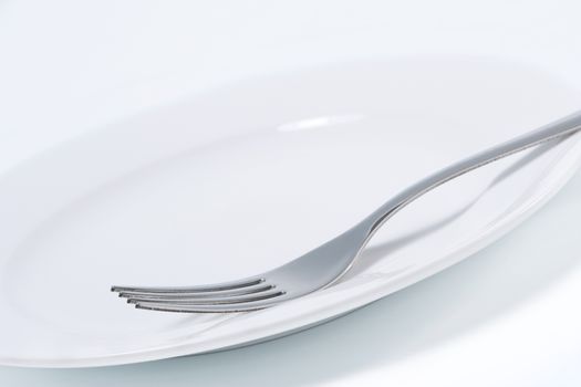 Empty white plate and fork