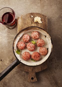Meatballs cooking with mince, parsley, parmesan, wine and eggs.