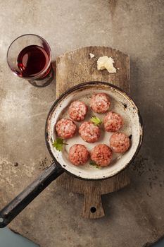 Meatballs cooking with mince, parsley, parmesan, wine and eggs.