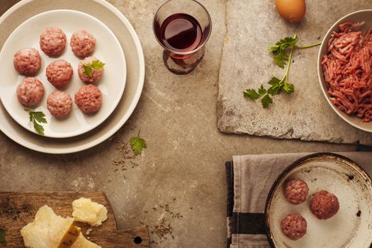 Meatballs cooking with mince, parsley, parmesan, wine and eggs.