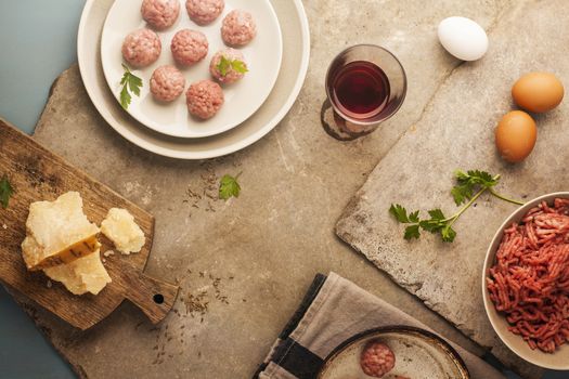 Meatballs cooking with mince, parsley, parmesan, wine and eggs.