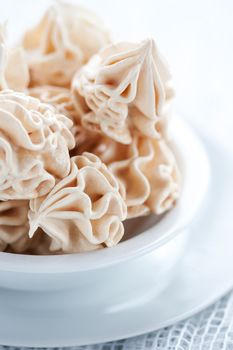 Meringues on white tablecloth, shallow dof.