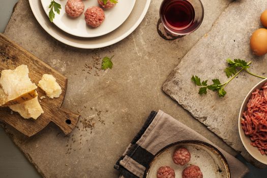 Meatballs cooking with mince, parsley, parmesan, wine and eggs.