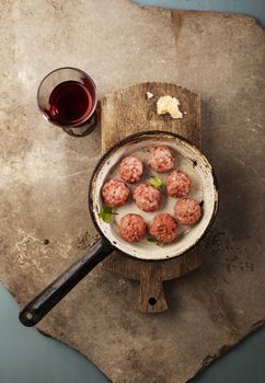 Meatballs cooking with mince, parsley, parmesan, wine and eggs.