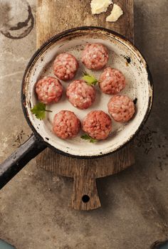 Meatballs cooking with mince, parsley, parmesan, wine and eggs.