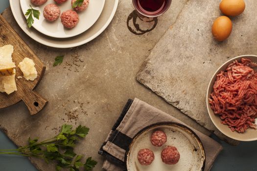 Meatballs cooking with mince, parsley, parmesan, wine and eggs.