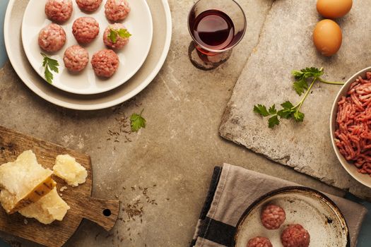 Meatballs cooking with mince, parsley, parmesan, wine and eggs.