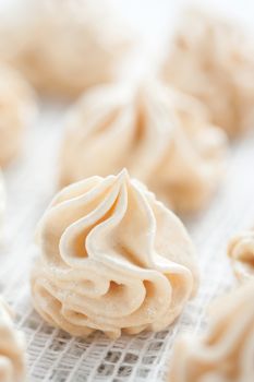 Meringues on white tablecloth, shallow dof.