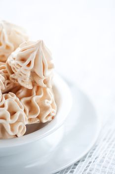 Meringues on white tablecloth, shallow dof.