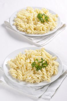 Two plates of pasta with parsley