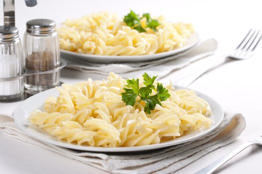 Two plates of pasta with parsley
