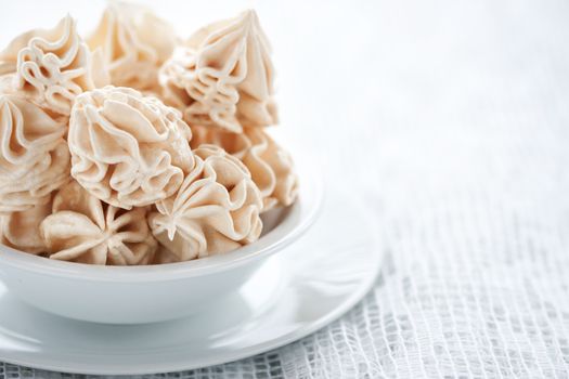 Meringues on white tablecloth, shallow dof.