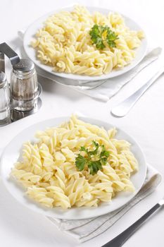 Two plates of pasta with parsley