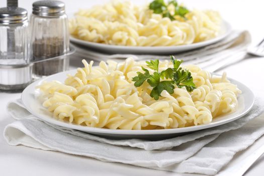 Two plates of pasta with parsley