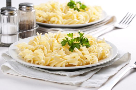 Two plates of pasta with parsley