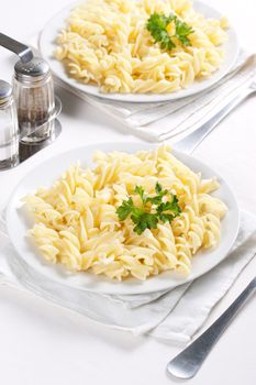 Two plates of pasta with parsley