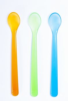 Colorful plastic spoons on white