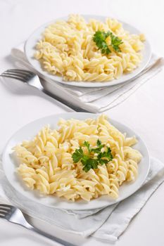 Two plates of pasta with parsley