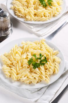 Two plates of pasta with parsley