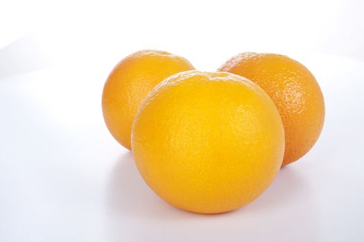 Three ripe oranges on white background