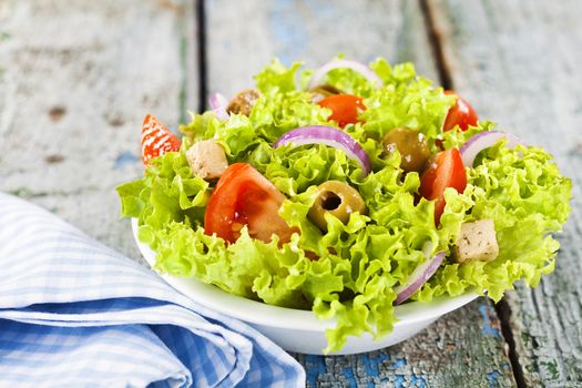 Delicious vegetable salad on rustic background