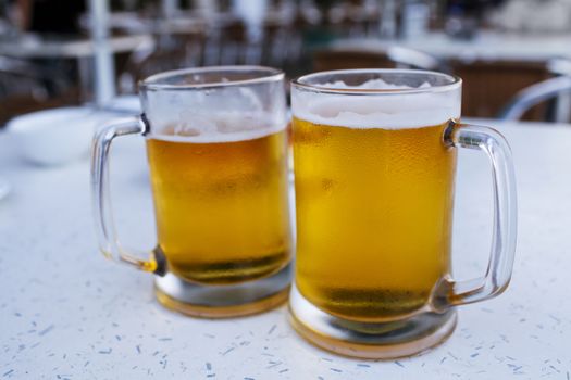 Two mugs of beer in pub