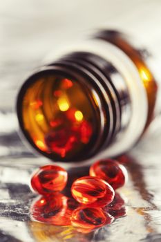 Orange vitamin pills and pill bottle