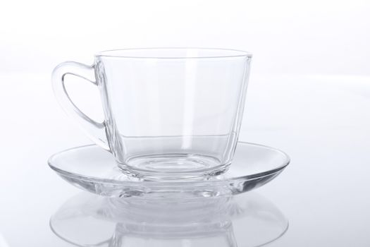 Empty transparent glass cup and saucer.
