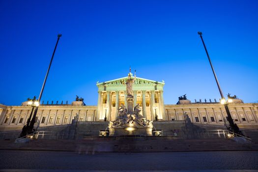 VIENNA, AUSTRIA - AUGUST 4, 2013: Austrian Parliament Building and The Athena Fountain at night.