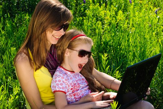 Smiling young mother with little daughter. Sunny summer day.