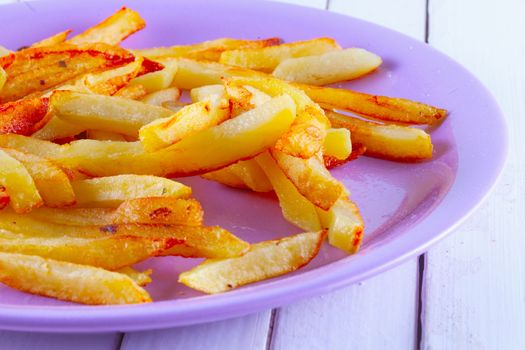 Fried potatoes over a purple plate, white table