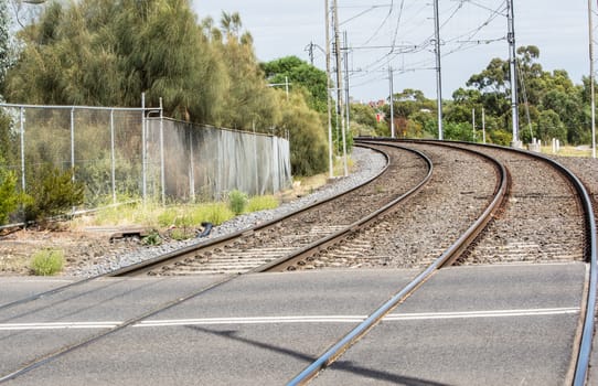 A railway turns up left through the spring green field.