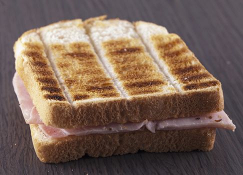 Toast with ham over dark wooden table