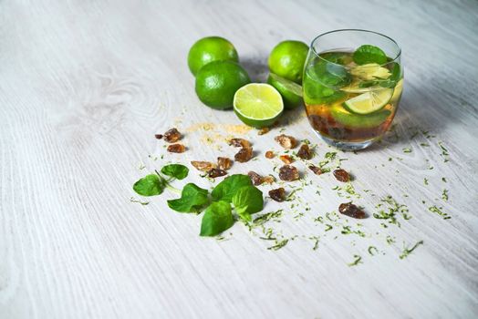 Mojito drink with limes, mentha and brown sugar still life.