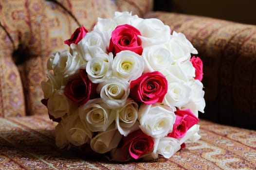 Brides red and white bouquet of roses closeup on wedding day