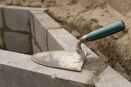 Empty trowel on a constructed wall outdoors