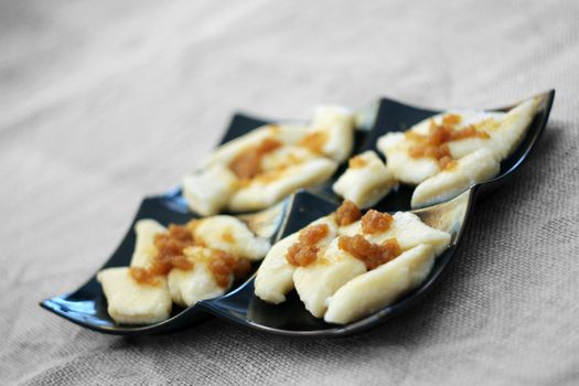 Cooked traditional lazy noodles with crumbs on black plate