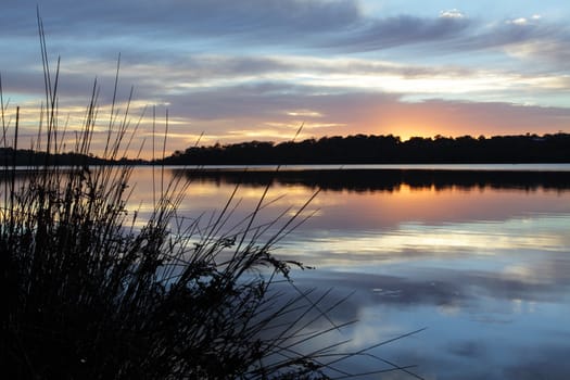 Tranquil scene at Narrabeen Lakes, Northern Beaches, Sydney. The muted colours after the intensity of sunrise fades.  Narrabeen Lakes flow into the ocean at North Narrabeen.
