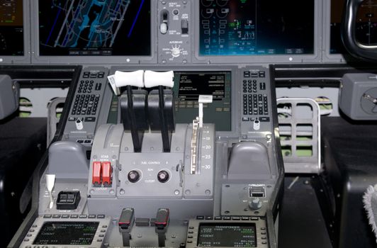 Cockpit detail of widebody airliner. Shallow depth of field with the foreground controls in focus.