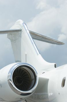 Tail plane and engine of white corporate jet airplane