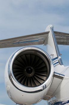 Engine and tail fin of white, luxury corporate jet