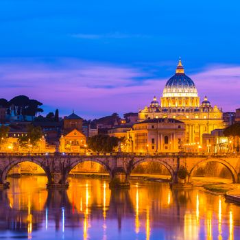 Night view of old roman Bridge of Hadrian and St. Peter's cathedral in Vatican City Rome Italy.