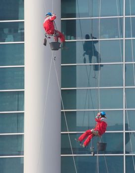 Climbers - window cleaners perform the work at wall of an office building