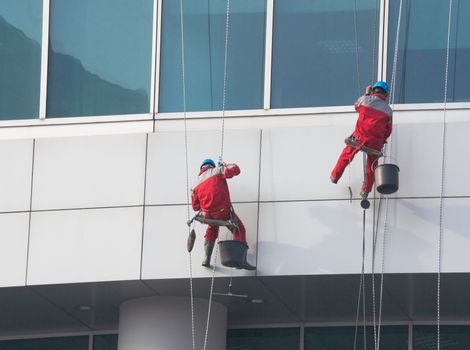 Climbers - window cleaners perform the work at wall of an office building