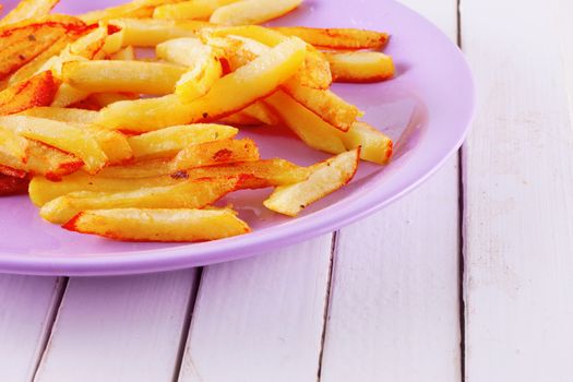 Fried potatoes over a purple plate, white table