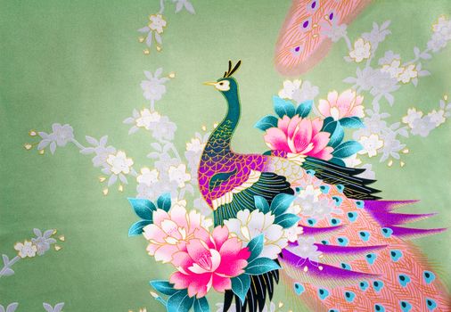 Beautiful silk fabric of light green color with the bright image of a peacock among flowers.g