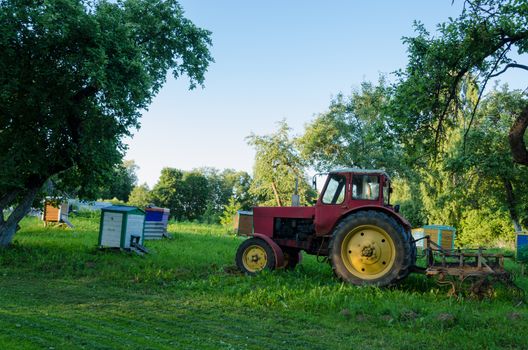 rural farm tractors in the summer garden to the hive