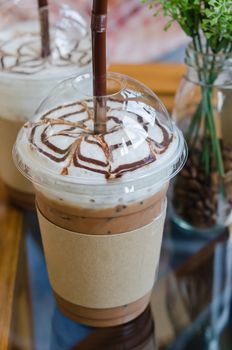 Iced coffee with straw in plastic cup