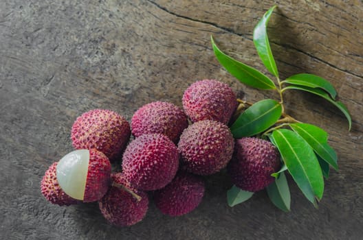 Lychee with leaves on a wooden table